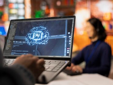 Call center worker uses AI technology on laptop to provide quick replies to common customer queries, close up. Customer service agent generates automated responses to clients using AI tech on notebook